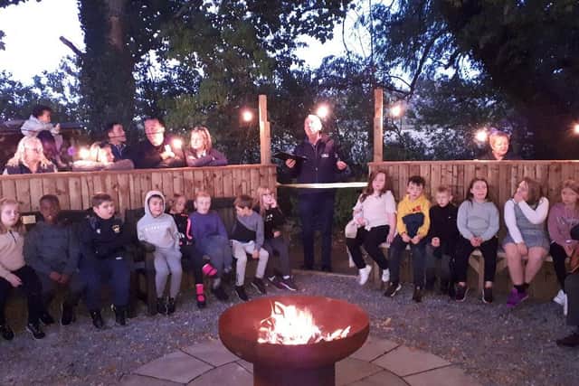 Stranton Primary School pupils gather round the camp fire in the newly created area at Carlton Adventure.