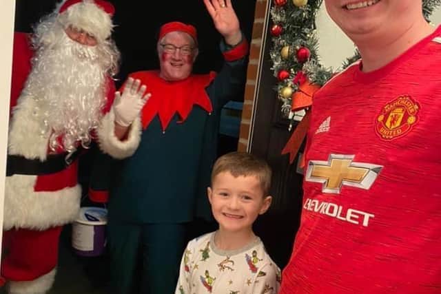 Smiles all round on this family's doorstep with an early visit by Santa.
