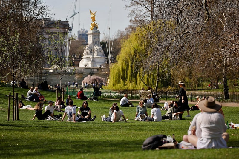 People enjoy the sunshine in St James's Park, central London on March 30, 2021, as England's third Covid-19 lockdown restrictions eased on March 29, allowing groups of up to six people to meet outside. (Photo by TOLGA AKMEN/AFP via Getty Images)