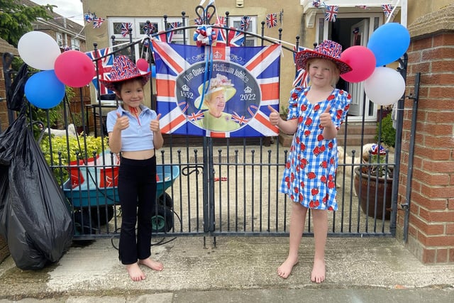 Molly Malcolm (left) and Molly Gibson standing next to the flags raised in honour of the Queen during the Jubilee Party at Lanark Road, Hartlepool. Picture by FRANK REID