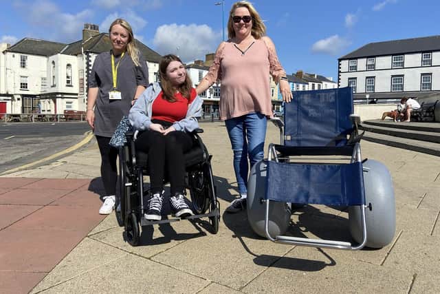 Charlotte Wilson in her wheelchair with one of the volunteers (left) and Counillor Sue Little (right).