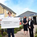 Iain Caldwell, CEO of Hartlepool and East Durham Mind, receives a cheque for £1,000 from Barratt and David Wilson's Elwick Gardens sales office staff.