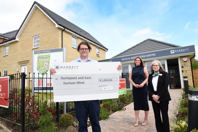 Iain Caldwell, CEO of Hartlepool and East Durham Mind, receives a cheque for £1,000 from Barratt and David Wilson's Elwick Gardens sales office staff.