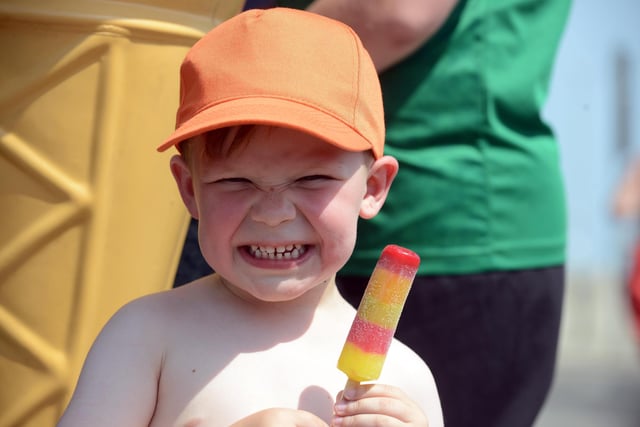 Arthur Renwick, three, smiles for the camera as he cools down with an ice lolly.