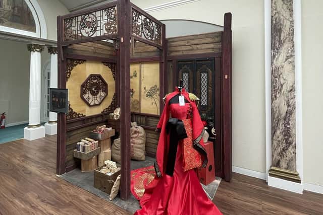 A Chinese red dress created for an Asian princess, featured inside a full-scale set of Chinese apothecary. Made by Cindy Ng.