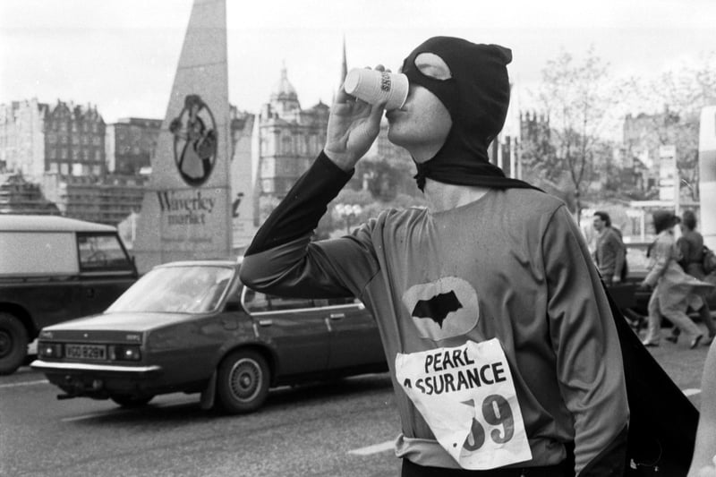 Volunteers hand out refreshments to runners in the Edinburgh half marathon at the east end of Princes Street in May 1987. Some competitors ran in fancy dress - Batman has a cup of water.