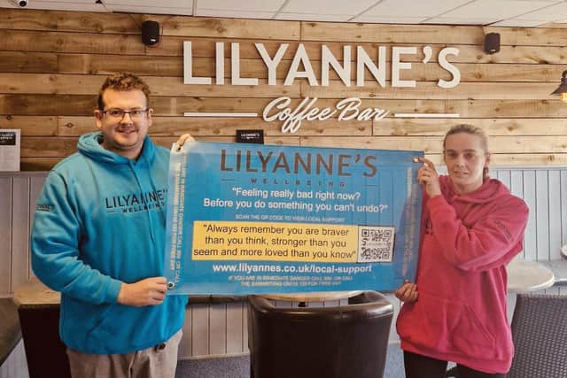 Trevor Sherwood and Angela Arnold of LilyAnne's with one of the new mental health banners.