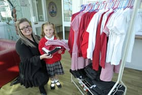 St Helen's Primary school pupil Hettie Turner and Inclusion and Family Support Assistant Aimee Small restock clothing onto a rack for the uniform swap shop. Picture by Frank Reid.