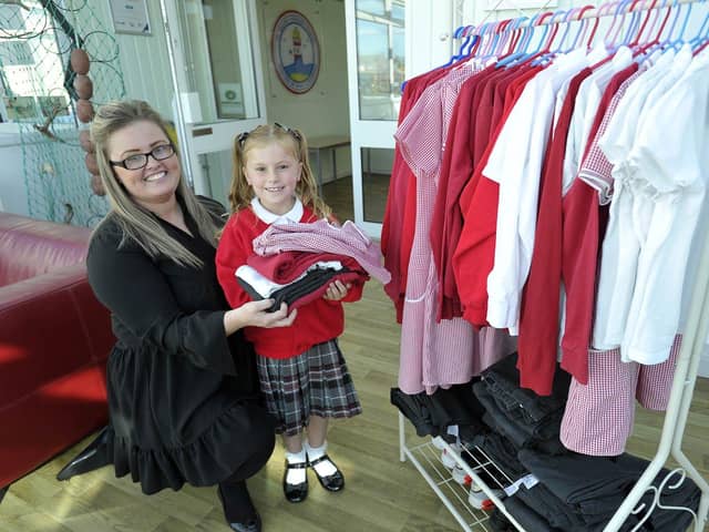 St Helen's Primary school pupil Hettie Turner and Inclusion and Family Support Assistant Aimee Small restock clothing onto a rack for the uniform swap shop. Picture by Frank Reid.