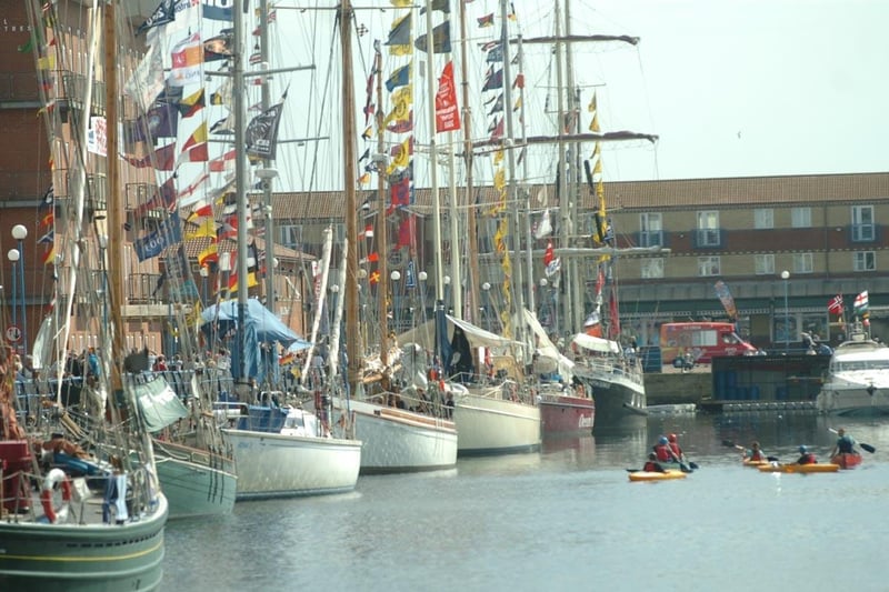 Kayakers admire the Tall Ships up close.