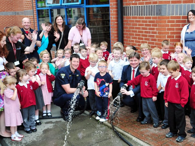 Hartlepool MP Iain Wright and Stranton Fire Station watch manager Steve Kitching with West View Nursery pupils and staff at a Book Start event at the Central Library in 2014.