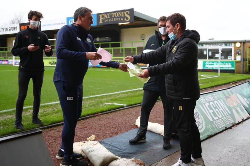 Protective masks are worn as team sheets are handed in before the game at Forest Green.