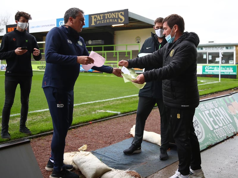 Protective masks are worn as team sheets are handed in before the game at Forest Green.