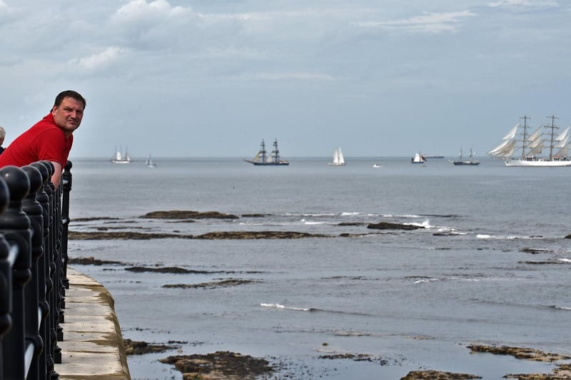 Visitors watching the Parade of Sail taking place off the Headland at the end of the Tall Ships festival.