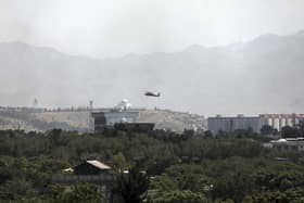A. US Black Hawk military helicopter flies over the city of Kabul, Afghanistan, Sunday, Aug. 15, 2021. Taliban fighters entered the outskirts of the Afghan capital on Sunday and said they were awaiting a 'peaceful transfer' of the city after promising not to take it by force, but amid the uncertainty panicked workers fled government offices and helicopters landed at the US Embassy. (AP Photo/Rahmat Gul)