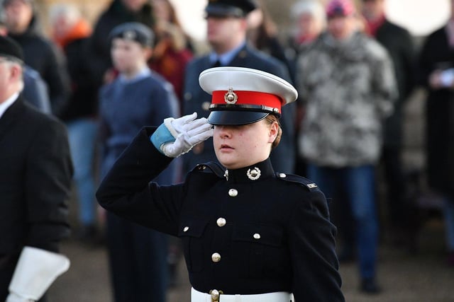 A member of the Hartlepool Royal Marine Cadets salutes after placing her cross at Redheugh Gardens Memorial.