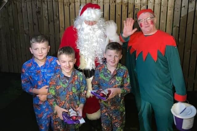 Santa and Elf Les Watts brought a smile to these three boys.