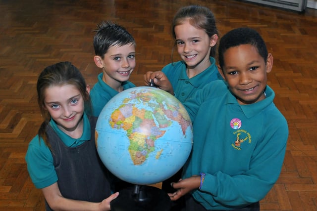 Clavering Primary School pupils Mia, Luke, Ellie-Mae and Duane hold the globe in their hands in 2012.