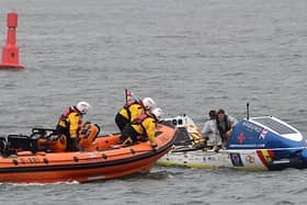 Hartlepool RNLI inshore lifeboat and volunteer crew alongside the rowing boat.