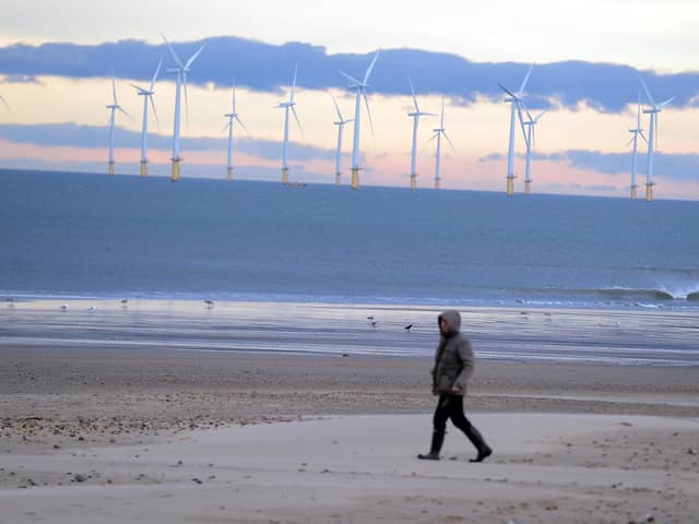 A walker on the beach at Seaton Carew.