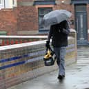 A walker takes shelter during Monday's downpours in Hartlepool.