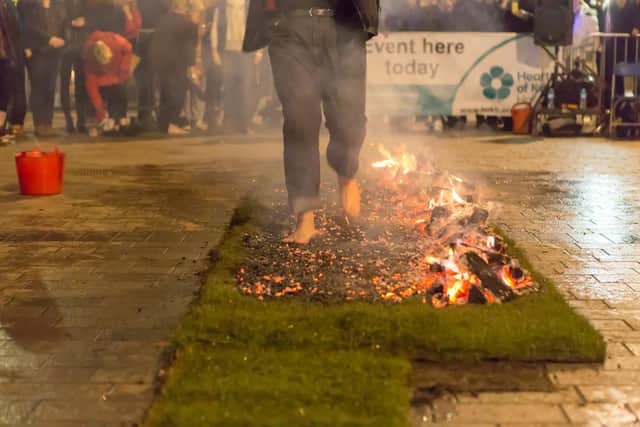 Fundraiser walks over hot coals in fire walking challenge.