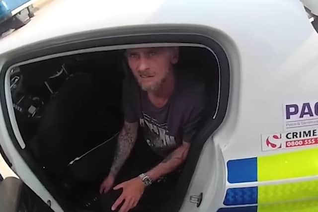 Drug dealer Anthony Thomas is taken away in a police car.