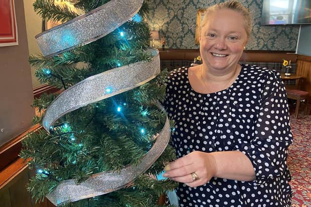 Deborah Humberston decorating a Christmas Tree in the Nursery Inn ahead of the pub's May 30 Christmas carol service.