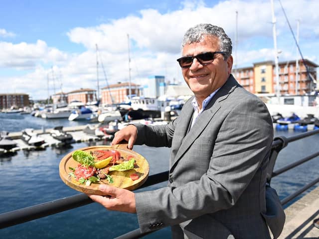 Darab Rezai, the new owner of Santonio Bar, on Navigation Point, with a delightful looking sea bass. Picture by FRANK REID