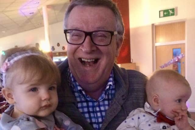 Keith Thomas raises a trademark smile with two of his grandchildren.