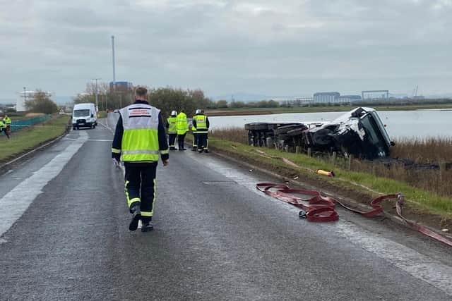 The tanker lying on its side after leaving the road