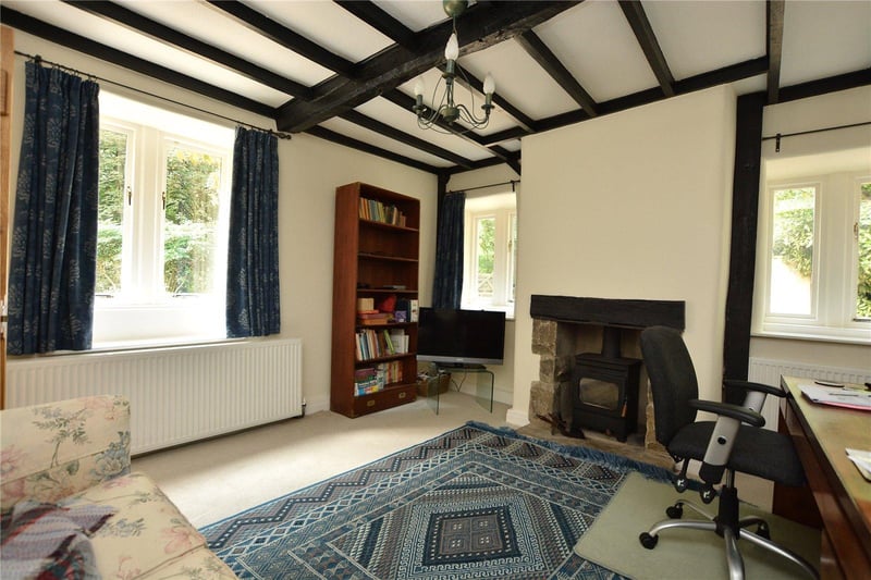 One of four reception rooms, this cosy sitting area features dual aspect windows and a dual fuel burning stove, and is currently also being used as a home study.
