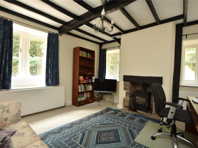 One of four reception rooms, this cosy sitting area features dual aspect windows and a dual fuel burning stove, and is currently also being used as a home study.