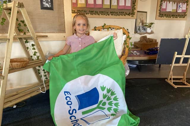 West View Primary School pupil Olivia Turner holds the Eco-Schools flag.