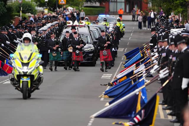 The cortege moves down Hutton Avenue to the church as standards from police forces around the country are lowered. Photo: PA