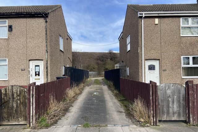 Bollards will shortly be placed between these two homes to prevent fly-tippers from driving down the lane to dump their waste.
