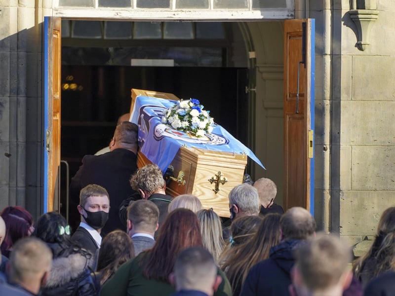 Many mourners arrived at the church carrying blue flowers as a tribute to Lewis.