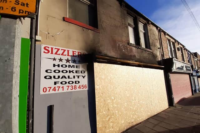 The front of the building shows the damaged caused by the blaze, while the front of the cafe has been boarded up.