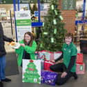 Helen Cook (left) gives a gift to Lyndsay Hastings (middle) and Jaden Burgess (right) who helped organise the Giving Tree.
