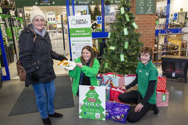 Helen Cook (left) gives a gift to Lyndsay Hastings (middle) and Jaden Burgess (right) who helped organise the Giving Tree.