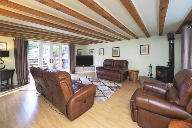 The tour begins in this lovely lounge, which is light, spacious and full of character. In the corner sits a feature free-standing log burner on an elevated hearth. The floor is laminated, and French doors open out into the garden.