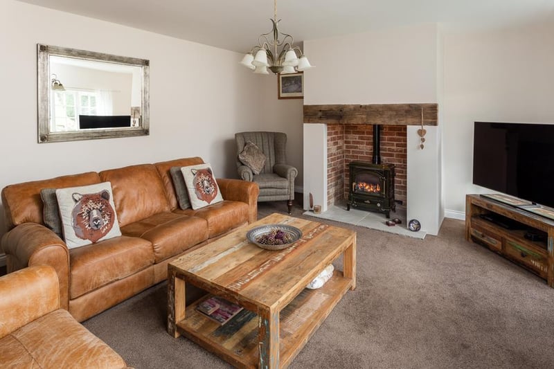 Cosy and spacious, the lounge is flooded with natural light from the windows to the front and benefits from a feature fireplace housing a living flame gas stove, inset in the chimney breast with an exposed brick back.