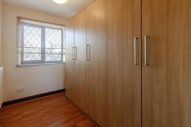 The third bedroom is the smallest, but there is still space for fitted wardrobes with hanging rails, shelving and drawers. The floor is laminated, and the window overlooks the back of the bungalow.