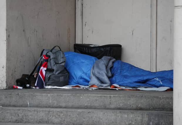 A homeless person sleeping rough in a doorway.