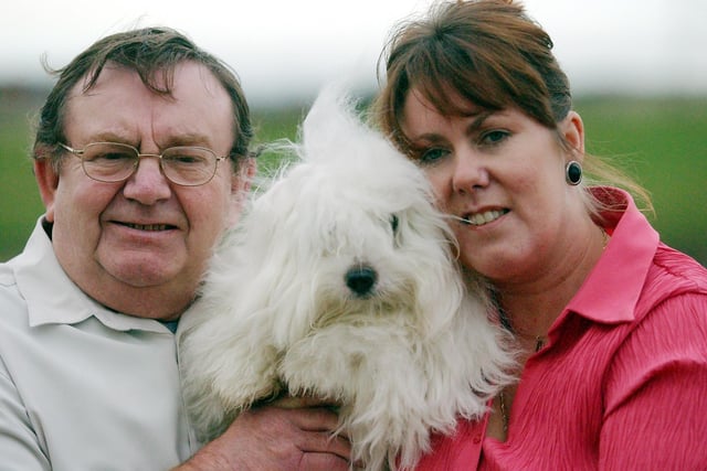 Toto the dog has a cuddle from his parents in 2004.