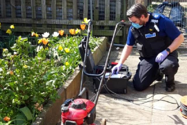 An officer property marks a lawnmower at Burn Valley allotments during the day of action.