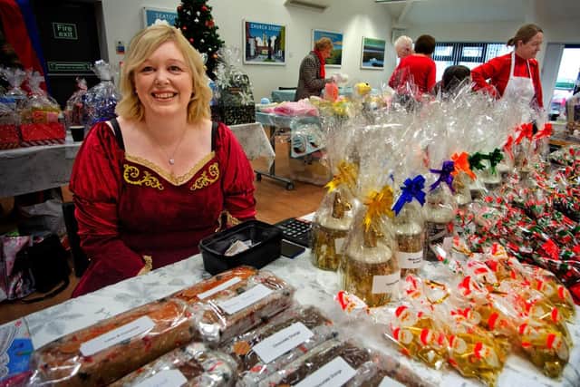 Community worker, Gill Baker, sells sweet treats on a stall at the Christmas fair.