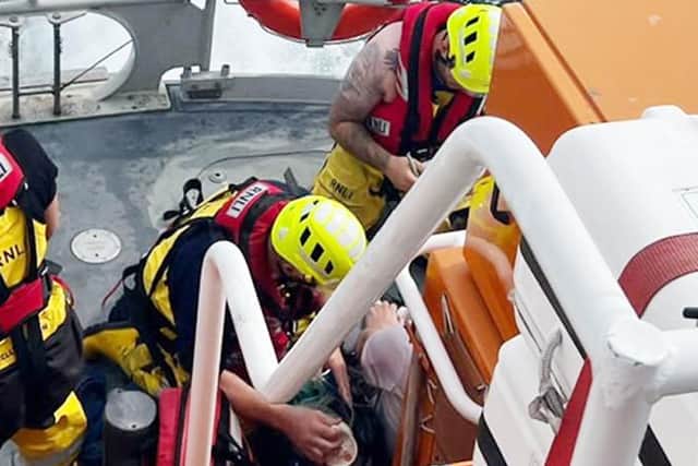 Hartlepool RNLI volunteer lifeboat crew members administering casualty care to the angler on the all weather lifeboat. Picture RNLI/Robbie Maiden.