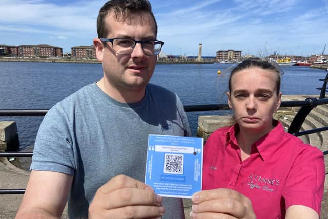 Trevor Sherwood and Angela Arnold of LilyAnne's Coffee Bar with one of the QR cards at Hartlepool marina. Picture by FRANk REID
