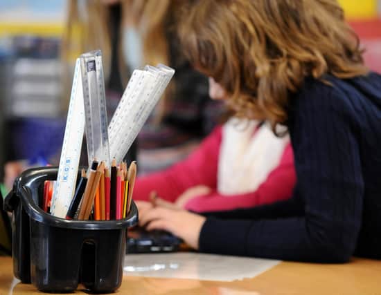 A generic stock photo shows Primary School children at work in a classroom.